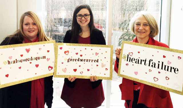 Members of the colloquium hold up signs showing hashtags to promote heart health