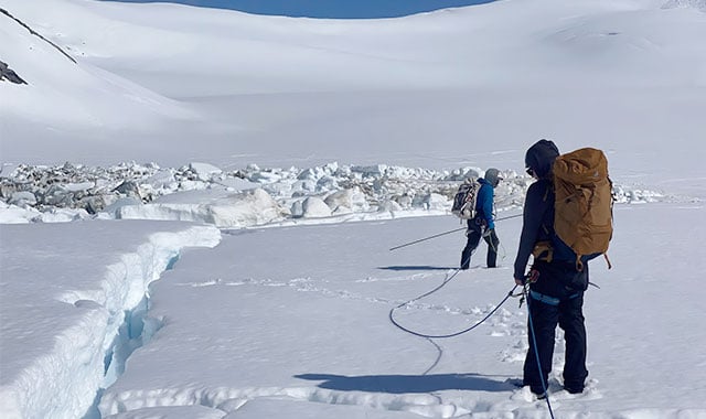 alt= battelle employees matt zeglen and andrew matas hiking an alaskan glacier during their time in jirp