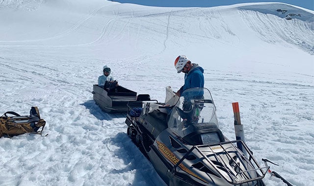 alt= battelle employees matt zeglen and andrew matas working in the field on their snowmobile