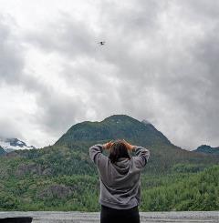 Photo: a upward bound stem student looking at a flying drone in the distance