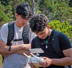 Photo: two upward bound stem students using a drone