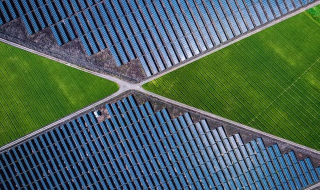 alt= a birdseye view of solar panels in a field