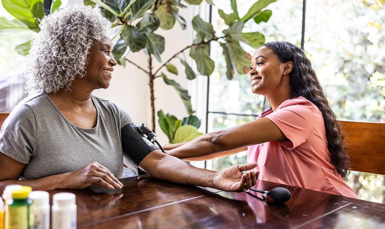 nurse taking a patients blood pressure at home