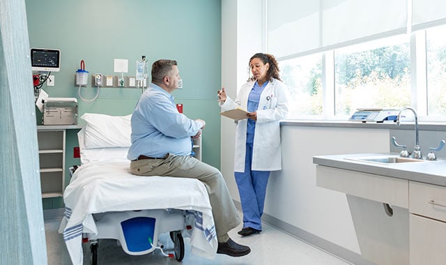 alt= a medical professionals advising a patient on an implantable drug delivery device.
