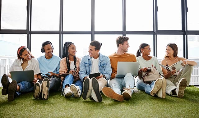 alt=interns seating on the ground while they study and laughing