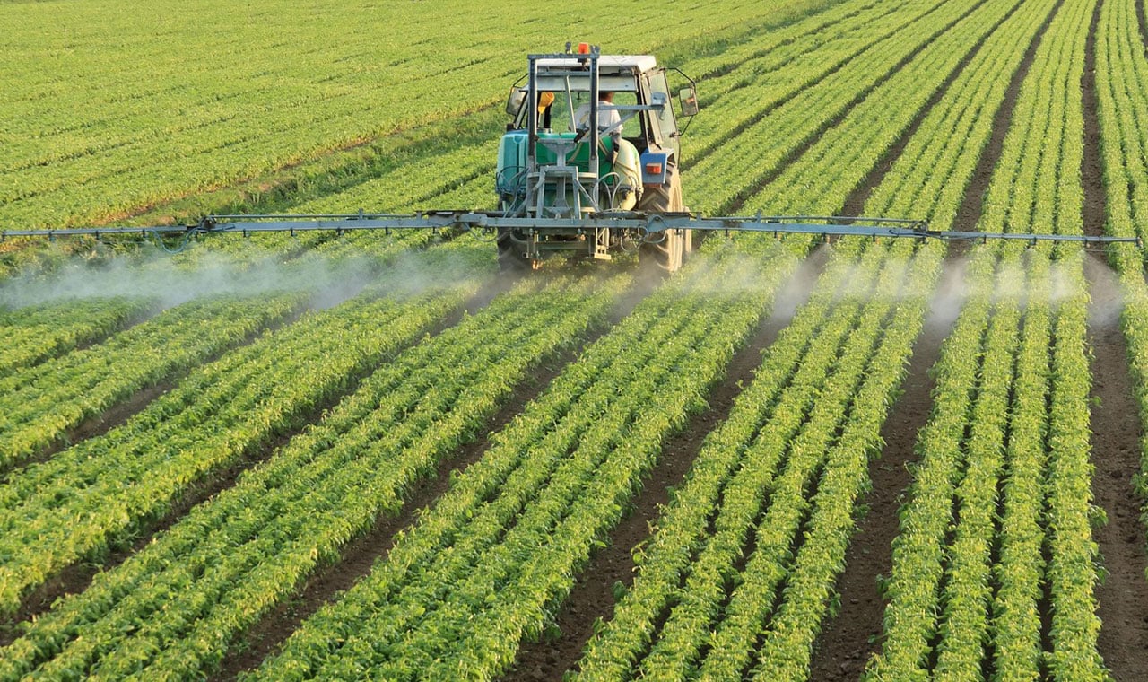 tractor spraying in field