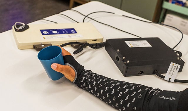 alt= a stroke patient using the neurolife sleeve for rehabilitation