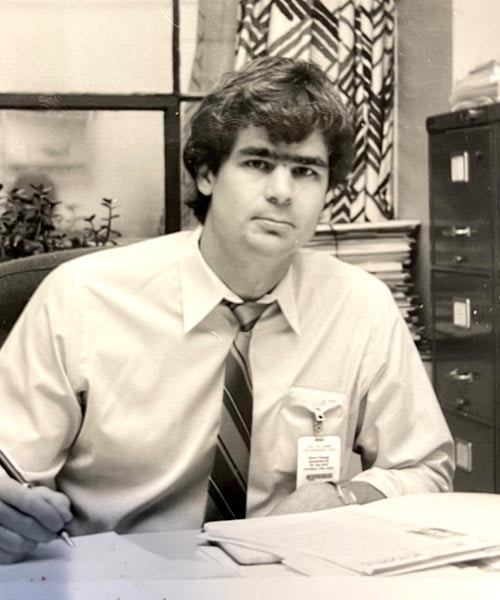 alt=young mike kuhlman working at his desk